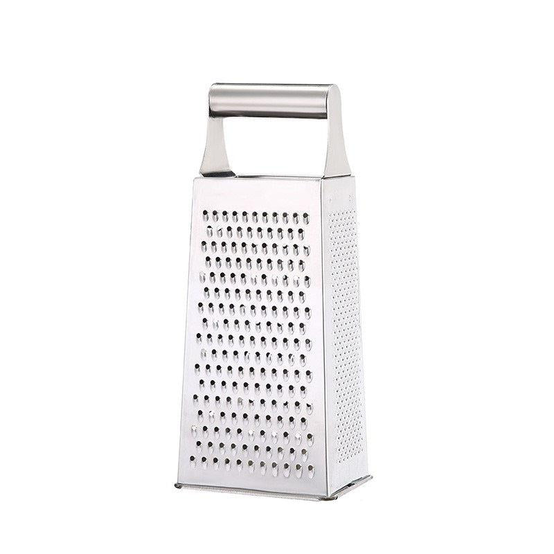 Four-sided stainless steel box grater on a countertop, ready for cheese or vegetable shredding