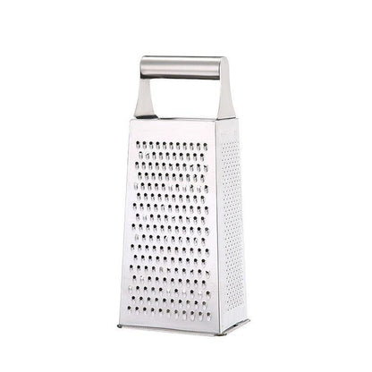 Four-sided stainless steel box grater on a countertop, ready for cheese or vegetable shredding