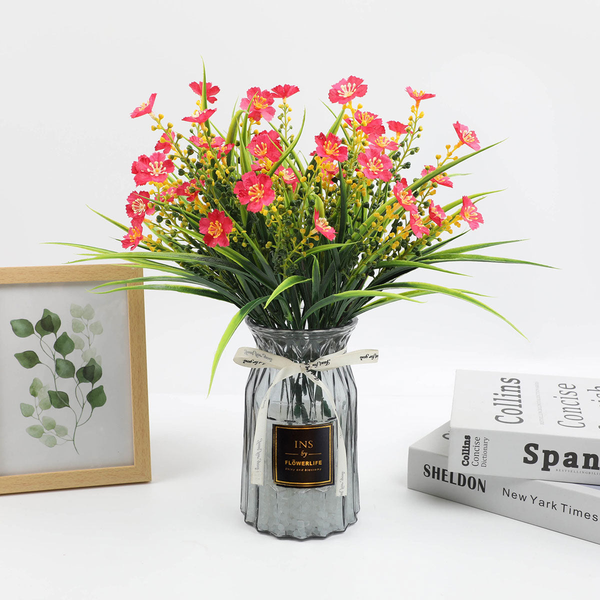 Spray-painted glass vase showcasing fresh flowers on a hotel side table